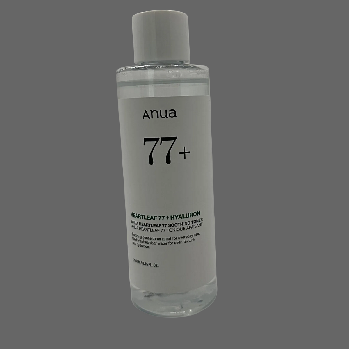 A clear plastic bottle of Anua 77+ Heartleaf Hyaluron Toner with a white cap and white label, set against a grey background. Bottle reads: Soothing gentle toner great for everyday use. Filled with heartleaf water for even texture and hydration.