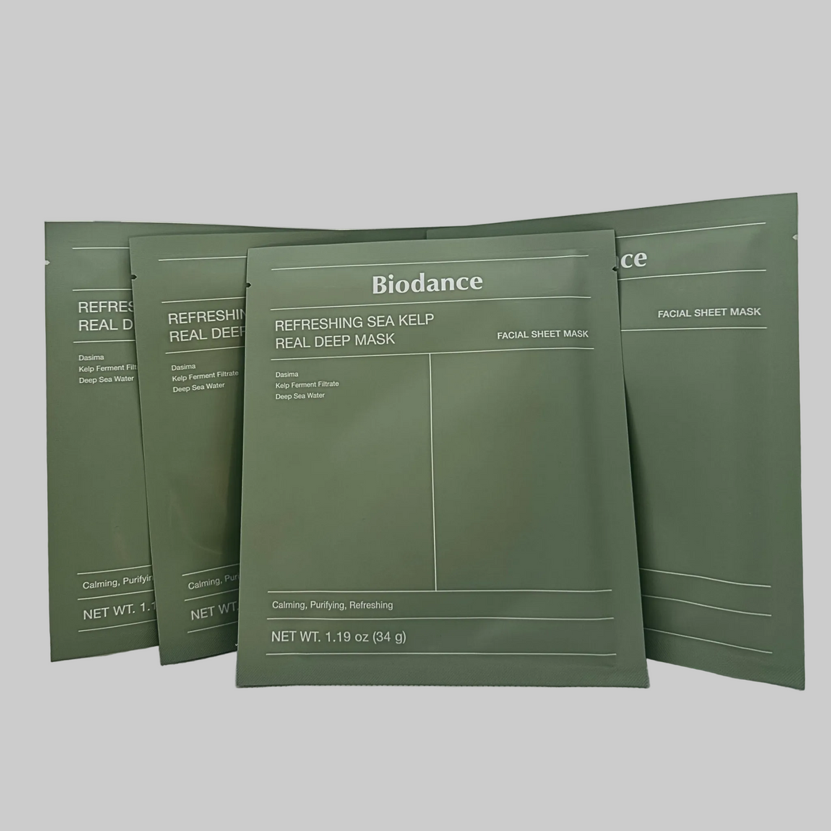 Four green Biodance facial sheet mask pouches arranged on a light gray background.