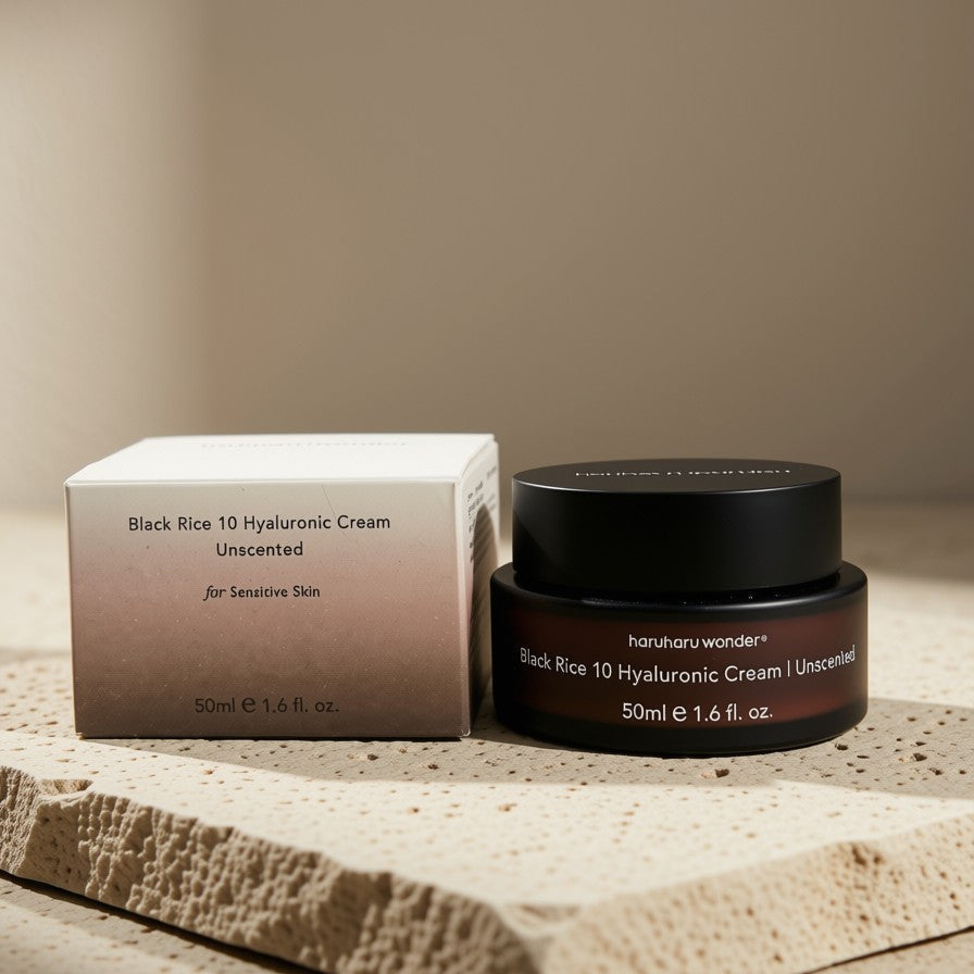 A jar of Haruharu Wonder Black Rice 10 Hyaluronic Cream 50ml alongside its matching outer box, styled on a textured stone slab against a warm beige background.