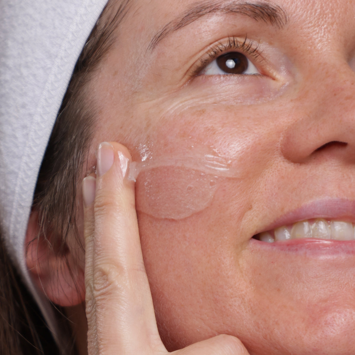 Woman applying Evolve Gentle Cleansing Melt to her face with a finger